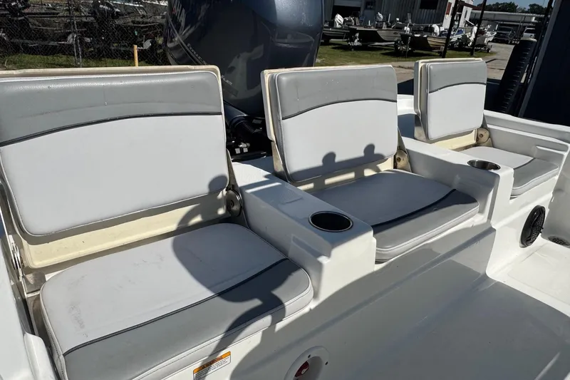 Slide: The Image of 2021 NauticStar 215 XTS Shallow Bay boat seating with cup holders, outdoor setting. - 20