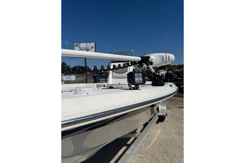 Slide: The Image of 2021 NauticStar 215 XTS Shallow Bay boat with trolling motor and spotlight, parked outdoors. - 6
