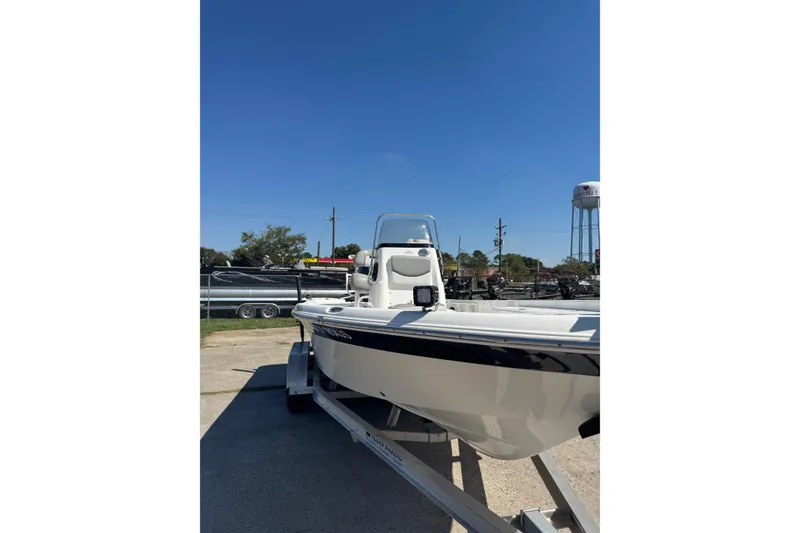 Slide: The Image of 2021 NauticStar 215 XTS Shallow Bay boat on trailer under clear blue sky. - 7