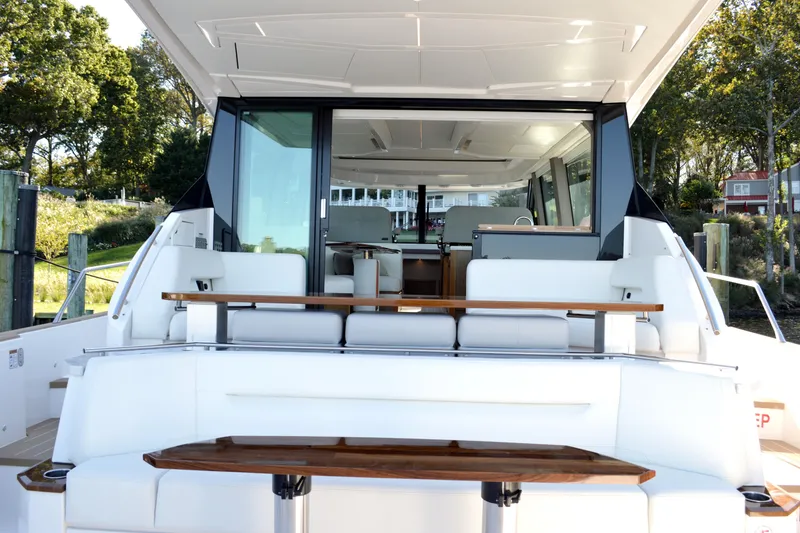 Slide: The Image of 2024 Tiara Yachts EX 60 luxury yacht interior with seating and table, docked outdoors. - 30