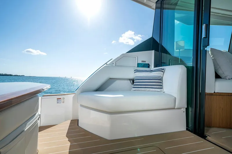 Slide: The Image of 2024 Tiara Yachts EX 60 interior with kitchen and seating area by the water. - 32