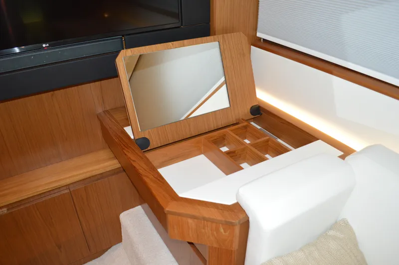 Slide: The Image of 2024 Tiara Yachts EX 60 interior with wooden vanity and mirror. - 65