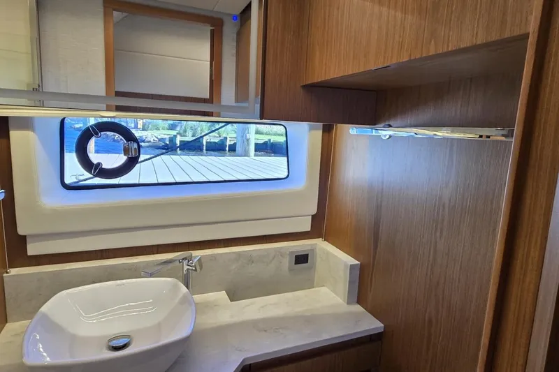 Slide: The Image of Luxurious bathroom interior of 2024 Tiara Yachts EX 60 with modern sink and window view. - 70