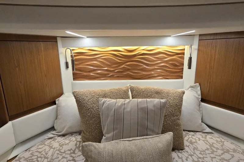 Slide: The Image of Luxurious 2024 Tiara Yachts EX 60 cabin interior with elegant wood paneling and plush pillows. - 72