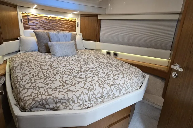 Slide: The Image of Luxurious bedroom interior of 2024 Tiara Yachts EX 60 with elegant bedding and wood accents. - 73