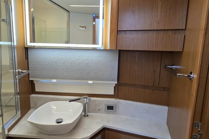 Slide: The Image of Luxurious bathroom interior of 2024 Tiara Yachts EX 60 with modern sink and wood cabinetry. - 79