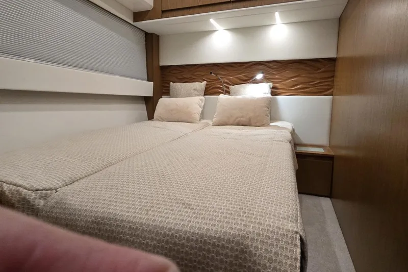 Slide: The Image of Luxurious bedroom interior of 2024 Tiara Yachts EX 60 with modern lighting and elegant bedding. - 82