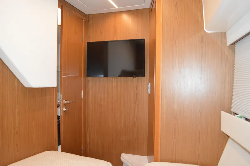 Slide: The Image of 2024 Tiara Yachts EX 60 interior with wood paneling and wall-mounted TV. - 83