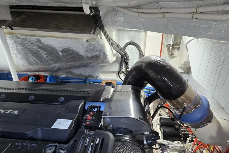 Slide: The Image of Engine room of 2024 Tiara Yachts EX 60, showcasing mechanical components and piping. - 93