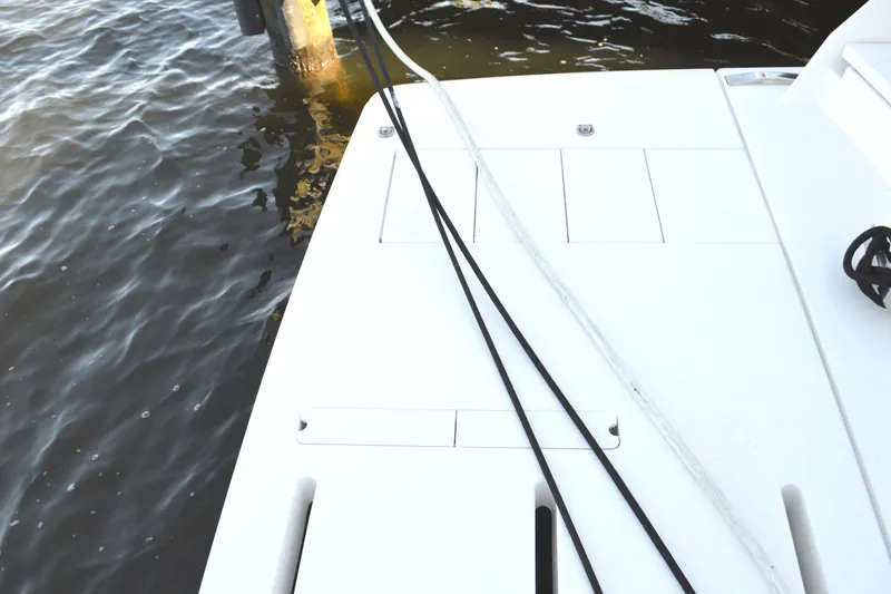 Slide: The Image of 2024 Tiara Yachts EX 60 swim platform with ropes, docked by water. - 95