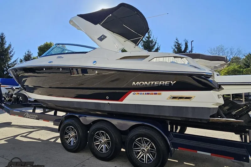 Slide: The Image of 2015 Monterey 288SS Super Sport boat on trailer, sleek design, black and white exterior. - 21