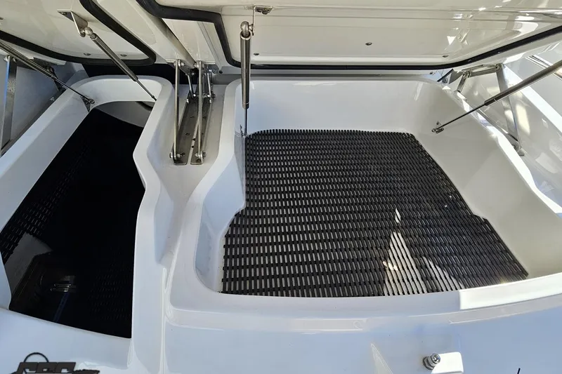 Slide: The Image of Open storage compartment of 2015 Monterey 288SS Super Sport boat, featuring hydraulic supports. - 33