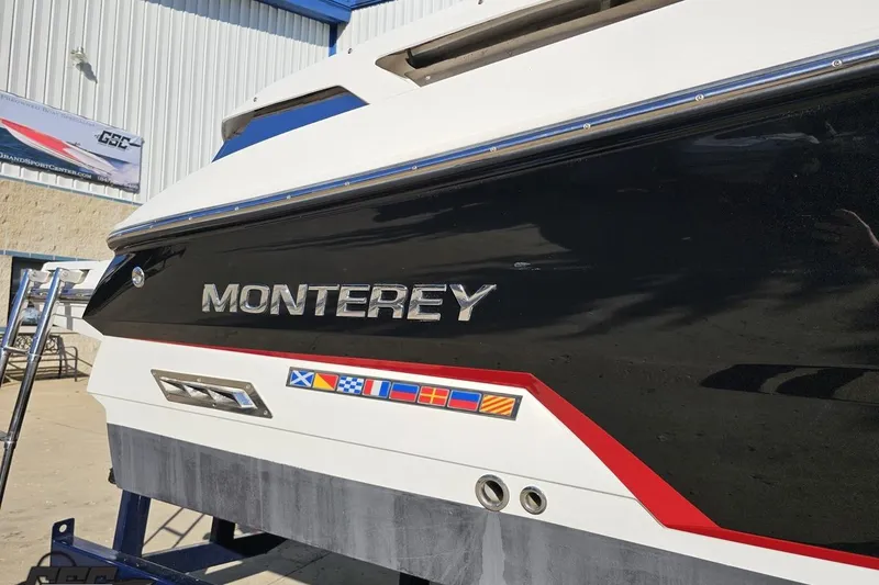 Slide: The Image of 2015 Monterey 288SS Super Sport boat with nautical flags, docked outdoors. - 6