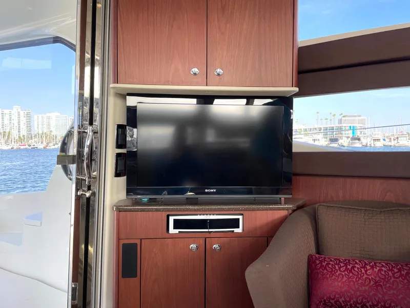Slide: The Image of 2012 Meridian 441 Sedan interior with TV, wooden cabinetry, and waterfront view. - 16