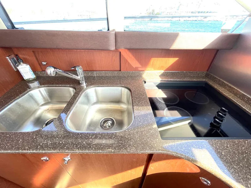 Slide: The Image of Modern kitchen area in a 2012 Meridian 441 Sedan yacht with sink and stove. - 19