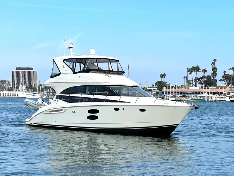 Slide: The Image of 2012 Meridian 441 Sedan yacht cruising on calm waters near a marina. - 2