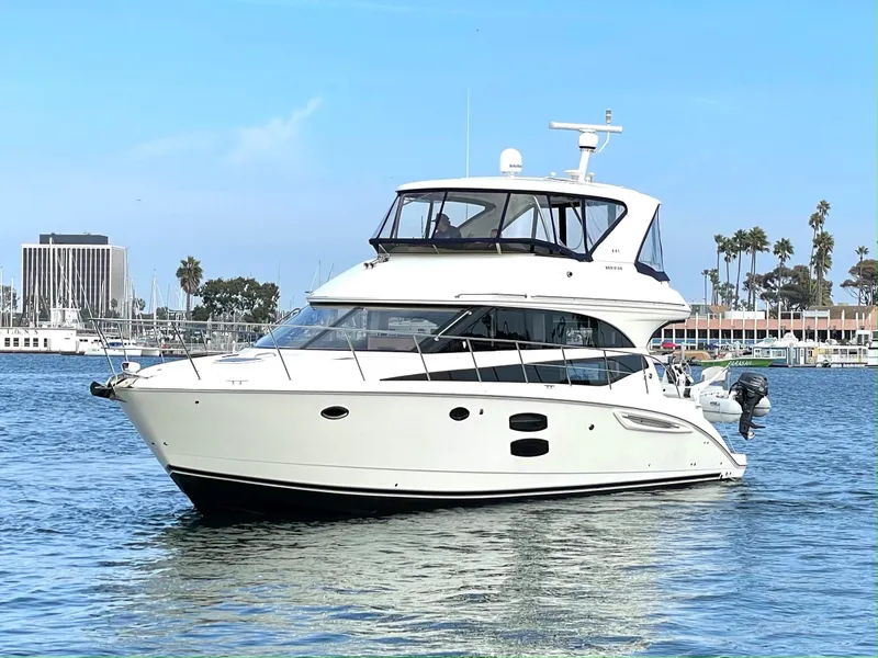 Slide: The Image of 2012 Meridian 441 Sedan yacht on calm water, clear sky, marina background. - 3