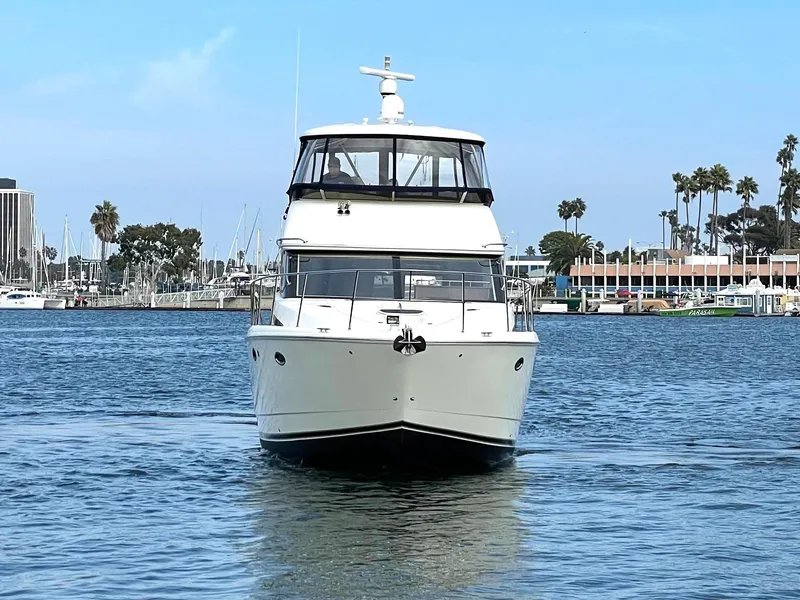 Slide: The Image of 2012 Meridian 441 Sedan yacht on calm water with marina backdrop. - 4