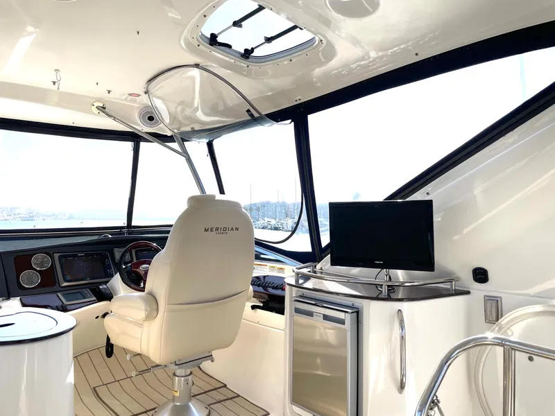 Slide: The Image of Interior of a 2012 Meridian 441 Sedan yacht with helm, chair, and TV. - 49
