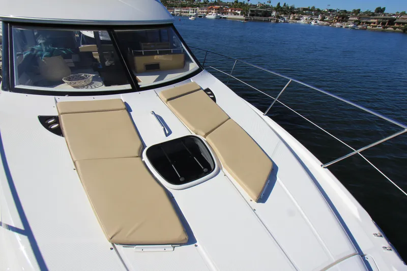 Slide: The Image of 2012 Meridian 441 Sedan yacht with sun pads on deck, docked in a marina. - 8