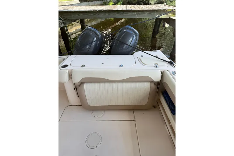 Slide: The Image of 2014 Grady-White Freedom 275 boat with dual outboard motors docked by water. - 14