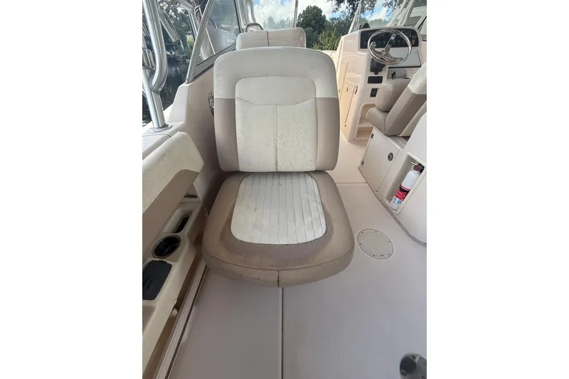 Slide: The Image of 2014 Grady-White Freedom 275 boat interior with beige seating and steering wheel. - 21