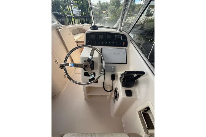Slide: The Image of 2014 Grady-White Freedom 275 boat helm with steering wheel and controls. - 25