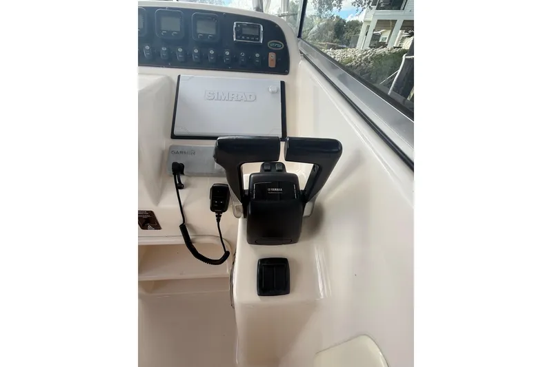 Slide: The Image of 2014 Grady-White Freedom 275 boat dashboard with Simrad and Garmin controls. - 26