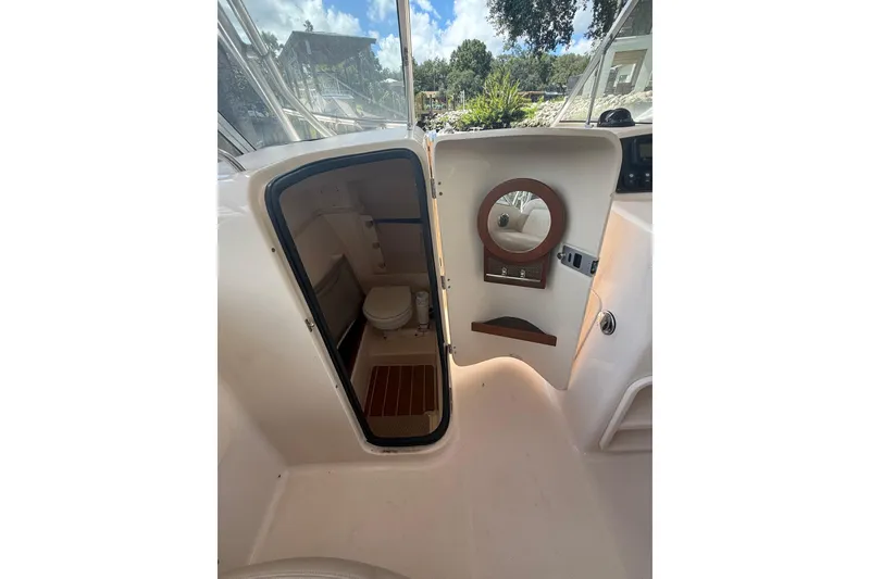 Slide: The Image of 2014 Grady-White Freedom 275 boat interior with open cabin door and visible toilet. - 37