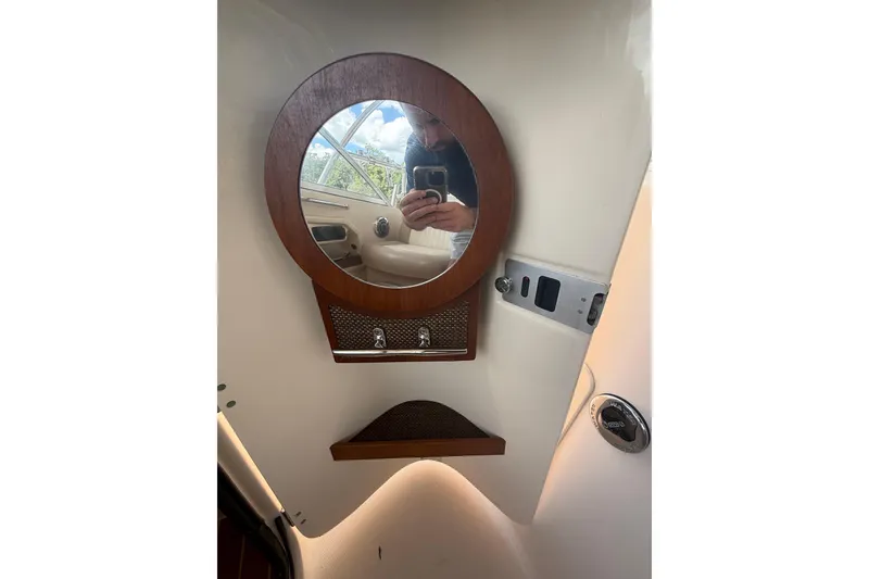 Slide: The Image of 2014 Grady-White Freedom 275 boat interior with round mirror and wooden accents. - 40