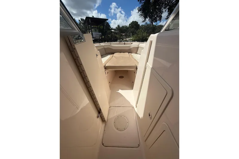 Slide: The Image of 2014 Grady-White Freedom 275 boat interior with seating and storage under a sunny sky. - 41