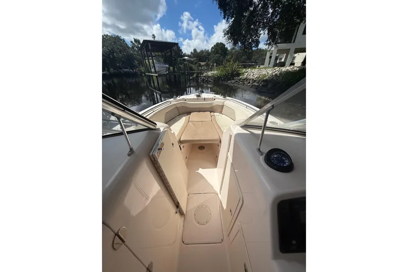 Slide: The Image of 2014 Grady-White Freedom 275 boat interior with seating, docked by a scenic waterway. - 42