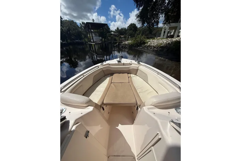 Slide: The Image of 2014 Grady-White Freedom 275 boat interior with seating, docked by a scenic river. - 43