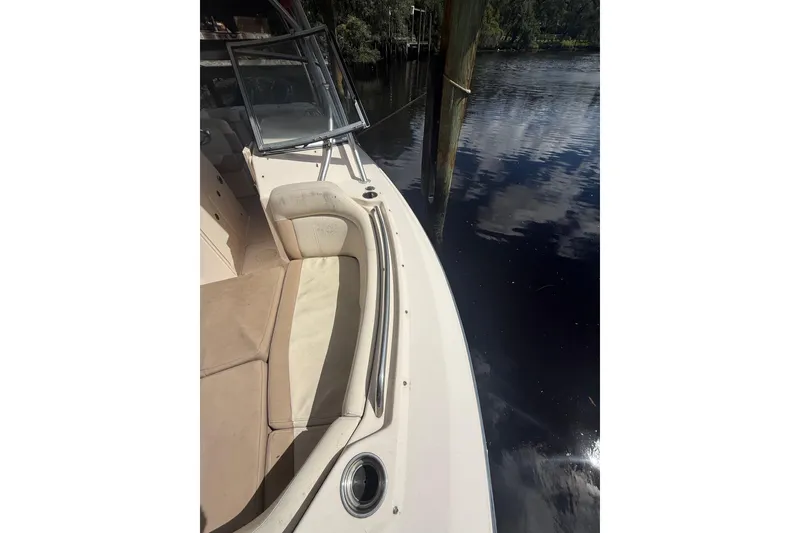 Slide: The Image of 2014 Grady-White Freedom 275 boat interior with seating, docked by calm water. - 51