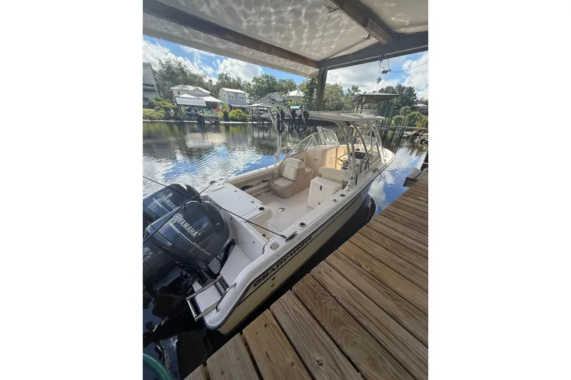 Slide: The Image of 2014 Grady-White Freedom 275 boat docked, featuring Yamaha engines, under a covered area. - 6