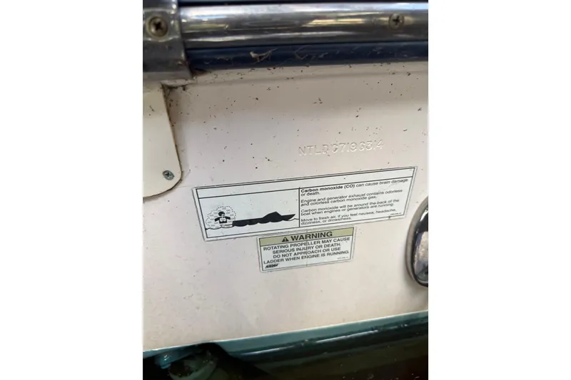 Slide: The Image of 2014 Grady-White Freedom 275 boat with safety warning labels and serial number. - 63
