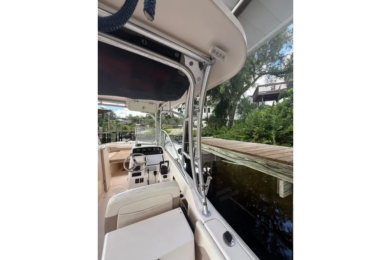Slide: The Image of 2014 Grady-White Freedom 275 boat interior with steering wheel and dock view. - 64