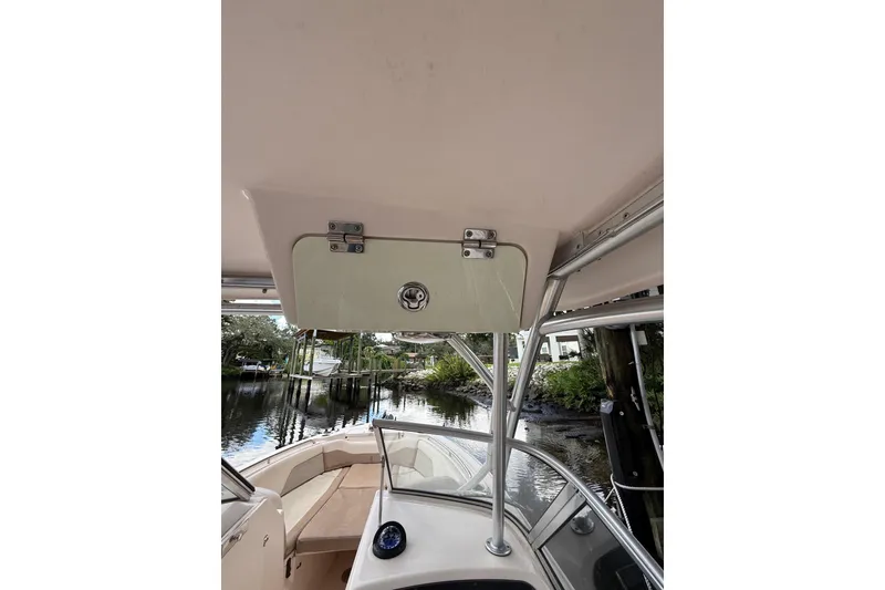 Slide: The Image of 2014 Grady-White Freedom 275 boat interior with storage compartment and scenic waterway view. - 66