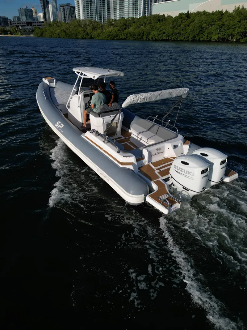Slide: The Image of 2024 Sea Prop COMFORT 30 boat cruising on a river with two outboard engines. - 7