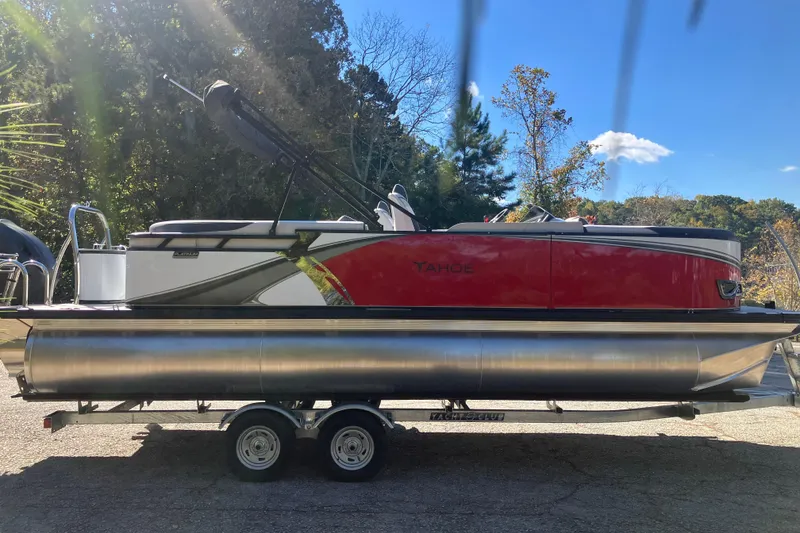 Slide: The Image of 2026 Tahoe Pontoon LTZ Quad Lounger on trailer, red and silver design, outdoor setting. - 4