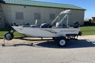Slide: The Image of 2013 Crestliner Fisherman 145 CS boat on trailer, parked outdoors near a building. - 1