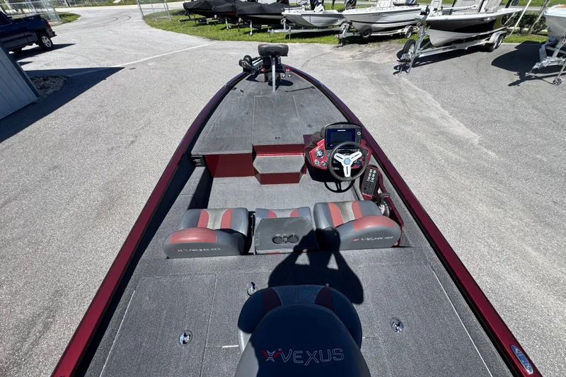 Slide: The Image of 2019 Vexus AVX2080 boat interior with steering console and seating, parked on pavement. - 15