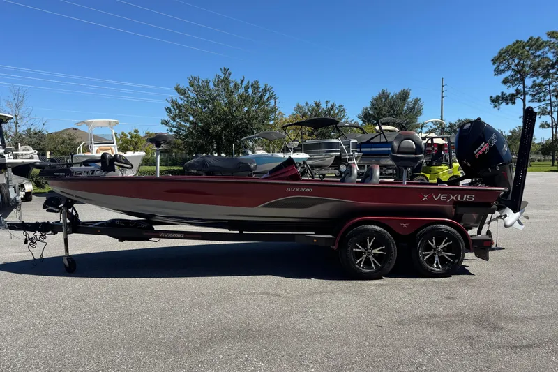 Slide: The Image of 2019 Vexus AVX2080 boat on trailer, parked outdoors under clear blue sky. - 5