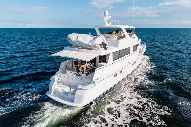 Slide: The Image of 2000 Hatteras 74 Cockpit Motor Yacht cruising on open sea under clear skies. - 11
