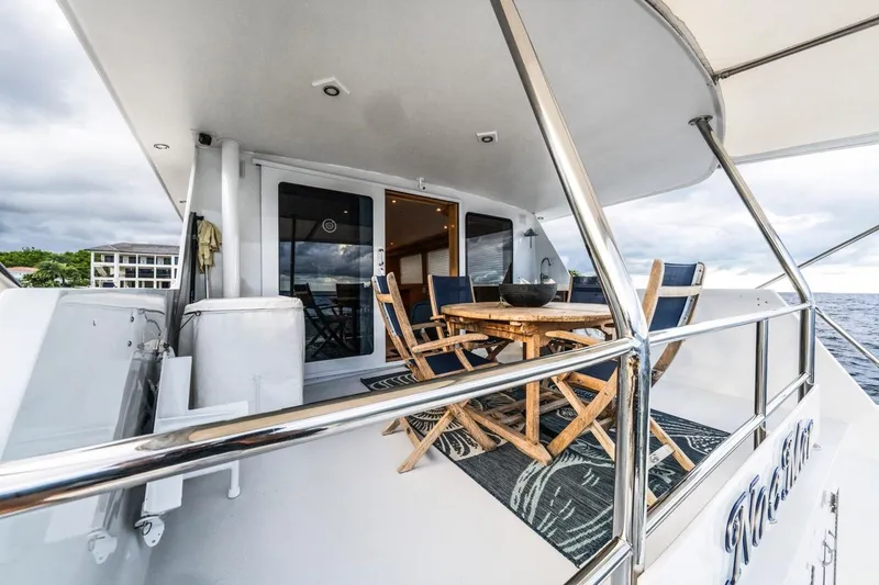 Slide: The Image of Hatteras 74 Cockpit Motor Yacht 2000, featuring outdoor seating and ocean view. - 25