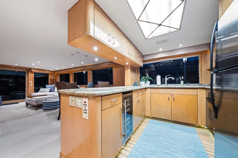 Slide: The Image of Luxurious interior of 2000 Hatteras 74 Cockpit Motor Yacht with modern kitchen and lounge area. - 34