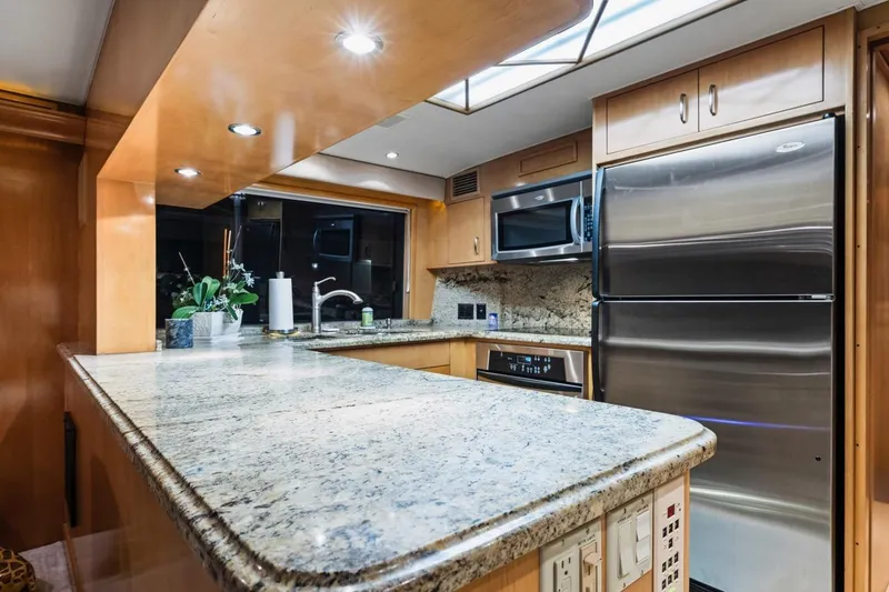 Slide: The Image of Luxurious kitchen interior of 2000 Hatteras 74 Cockpit Motor Yacht with granite countertops. - 35