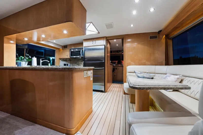Slide: The Image of Luxurious interior of 2000 Hatteras 74 Cockpit Motor Yacht with modern kitchen and dining area. - 36