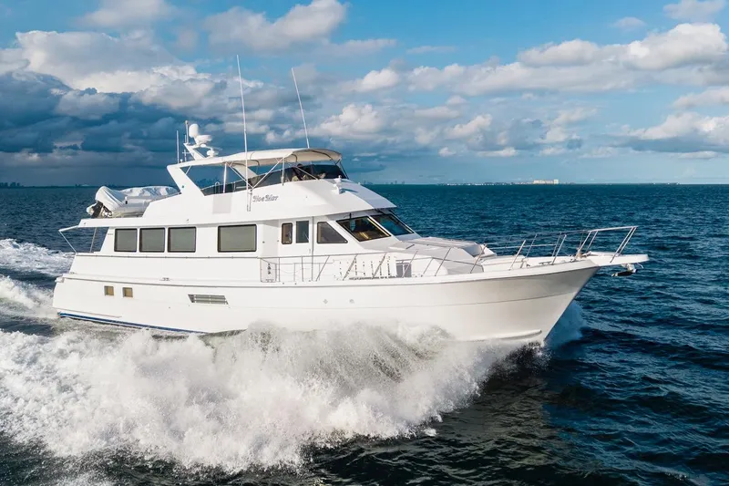 Slide: The Image of Hatteras 74 Cockpit Motor Yacht 2000 cruising on open sea under cloudy sky. - 4
