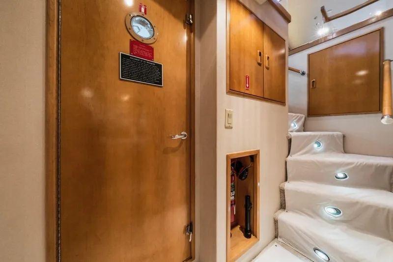 Slide: The Image of Interior of 2000 Hatteras 74 Cockpit Motor Yacht with wooden door and illuminated stairs. - 42